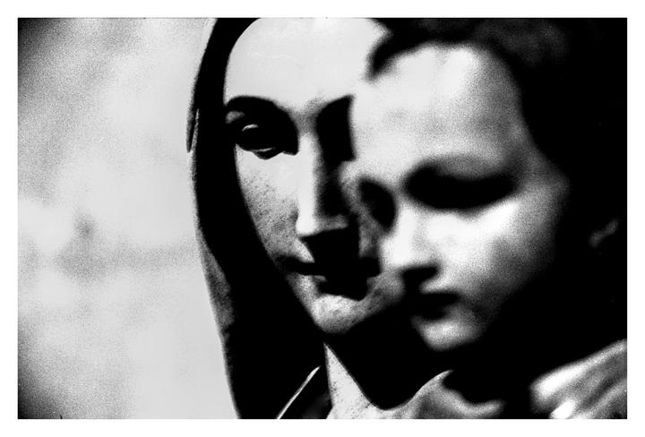 Two faces are visible in a high-contrast black and white image.