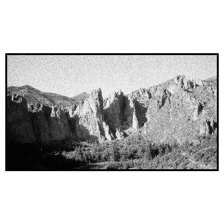 A panoramic landscape shows a rocky mountain range with trees in the valley below.