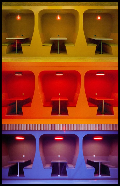 Three rows of booths are shown, each with a different color scheme and lighting.