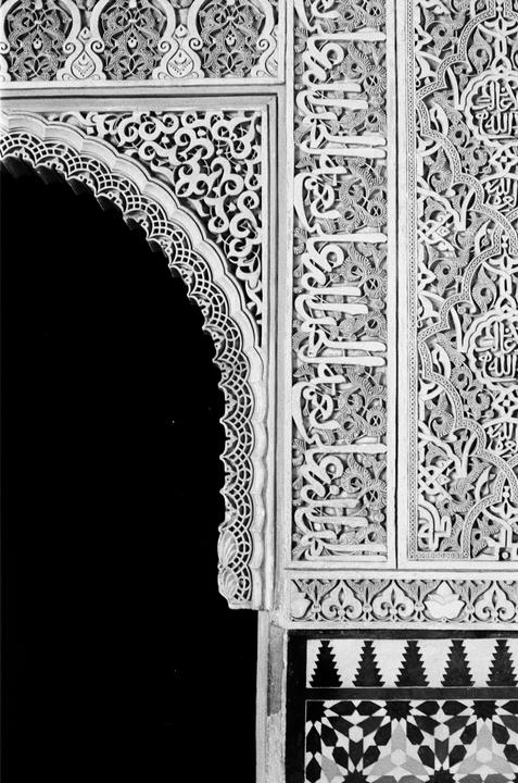 An ornate archway with intricate carvings and geometric patterns is visible.