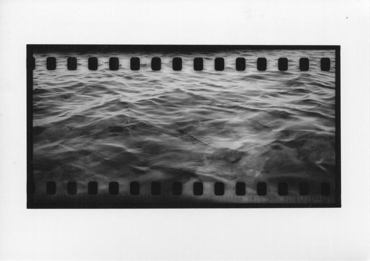 A black and white photograph shows a close-up of rippling water.