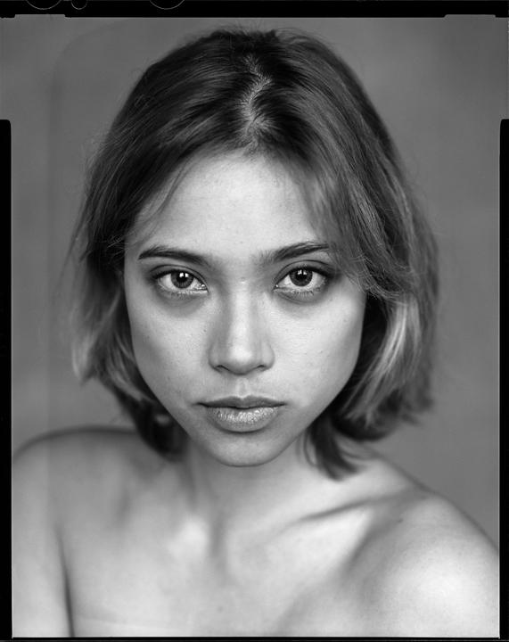 A woman with short hair looks directly at the viewer.