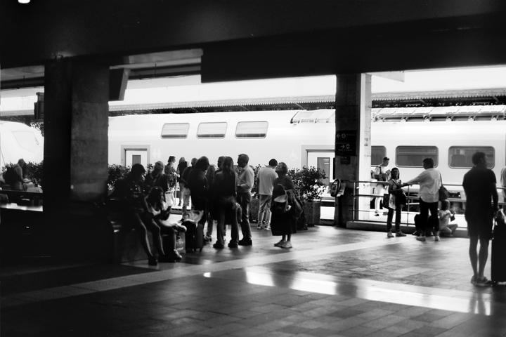 People are waiting on a train platform next to a train.