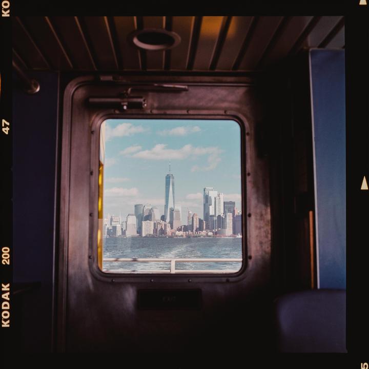 A view of the New York City skyline with the One World Trade Center from a ferry window.