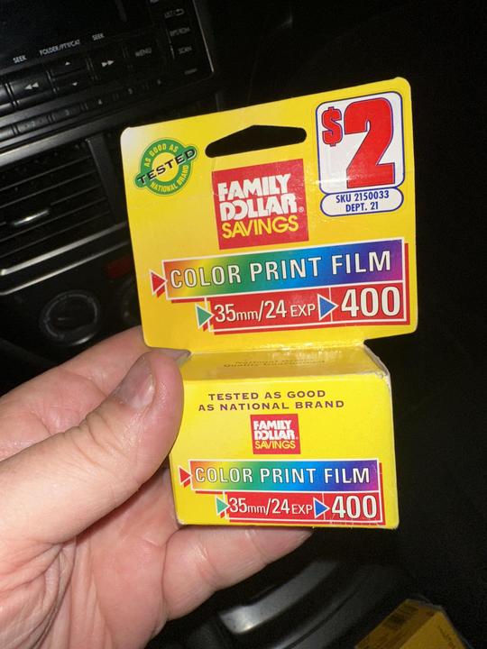 A hand holds a box of Family Dollar Savings color print film.