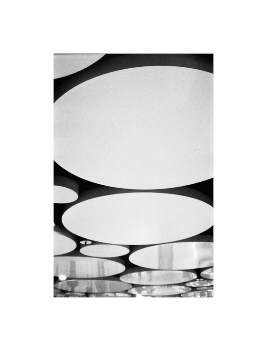 A black and white image shows a pattern of circular shapes on a ceiling.