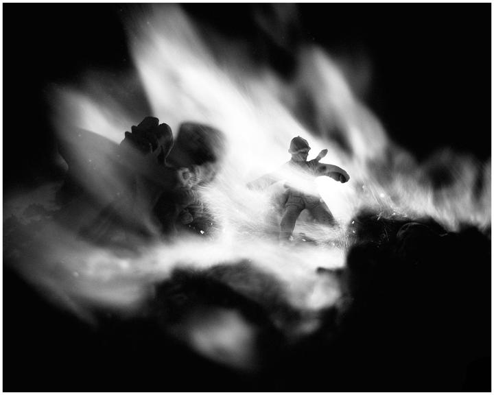 A toy soldier is illuminated by bright light and surrounded by smoke or mist.