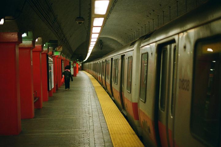 A person walks along a subway platform next to a train.