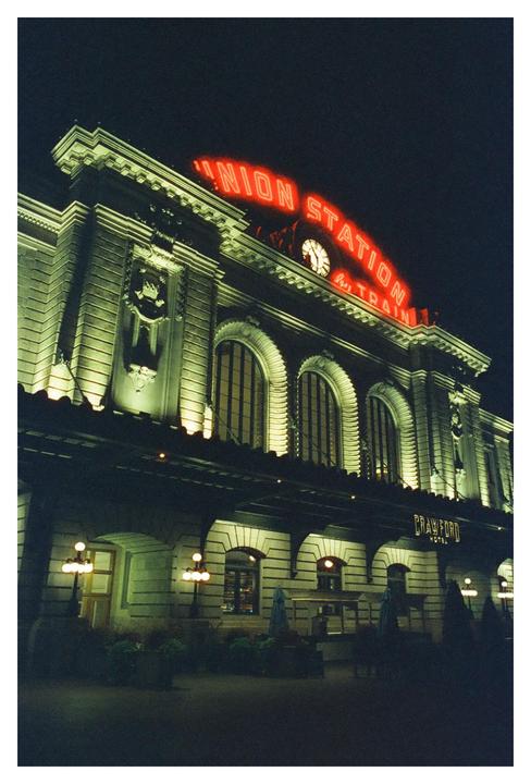 A building with a neon sign that reads "Union Station" is illuminated at night.