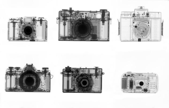 Six x-ray images of cameras are arranged in two rows of three against a white background.