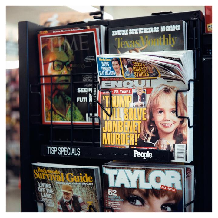 A magazine rack displays various publications, including one with a headline about solving a murder.