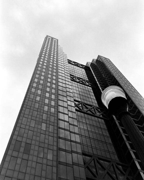 A low-angle view shows a tall building with many windows and a street light in the foreground.