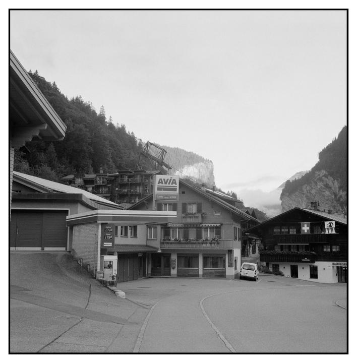 A gas station and other buildings are nestled in a mountain valley.