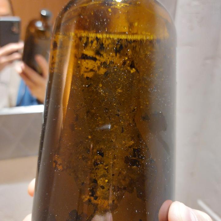 Hope this is allowed! My fixer started to precipitate silver, it's been accumulating on the walls of the bottle since about 2019. Today it began to peel away, so I strained it and melted it.