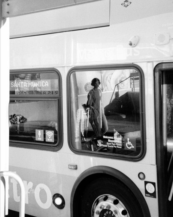 A woman is visible through the window of a bus that says "Santa Monica" on its destination sign.