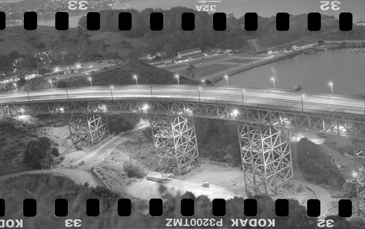 A long exposure shot of the Golden Gate Bridge at night shows car light trails and illuminated bridge structures.